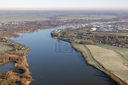 Aerial view flying above Dutch river Lek near Rotterdam with view at village Schoonhoven