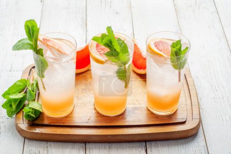 Téléchargez les photos : Summer refreshing fruit drinks with ice on a grey kitchen board. - en image libre de droit