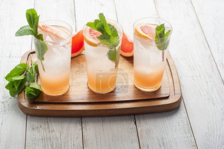 Foto de Summer refreshing fruit drinks with ice on a grey kitchen board. - Imagen libre de derechos