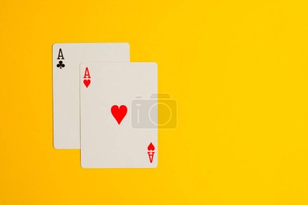 Photo for Two Ace playing cards on yellow background with copy space. - Royalty Free Image