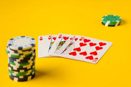 Téléchargez les photos : Royal Flush. Cinq cartes à jouer - la main flush royale de poker. jetons de poker sur jaune. succès dans le jeu - en image libre de droit