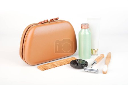 Photo for Premium traveling cosmetic bag with toiletries in the front isolated on white. Essential travel kit - Royalty Free Image