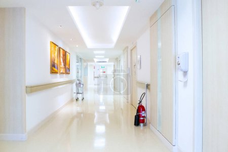 Monitor de pacientes signos vitales, máquina desinfectante de manos y extintor de incendios colocados en el pasillo del hospital de lujo.