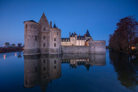 Foto de Sully Sur Loire, Francia - 13 de abril de 2019: Famoso castillo medieval Sully sur Loire al atardecer, valle del Loira, Francia. El castillo de Sully sur Loire data de finales del siglo XIV
. - Imagen libre de derechos