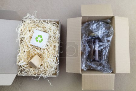 Téléchargez les photos : Before and after. Biodegradable filler in parcel packaging vs plastic filler. Box with a filler that does not harm the environment, and next to it is a box with harmful non-decomposing plastic. - en image libre de droit