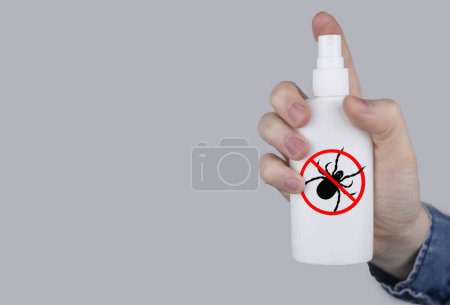Tick repellant. Insect protection. Girl holds a spray on a white background that will protect against ticks. Repelling blood-sucking insects.