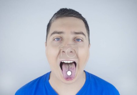 Orale Probiotika. Ein Mann legt sich eine Pille mit nützlichen Bakterien auf die Zunge. Dysbakteriose und Ungleichgewicht zwischen nützlichen und schädlichen Mikroorganismen im Mund. Stärkung der Immunität und Verbesserung der Gesundheit.