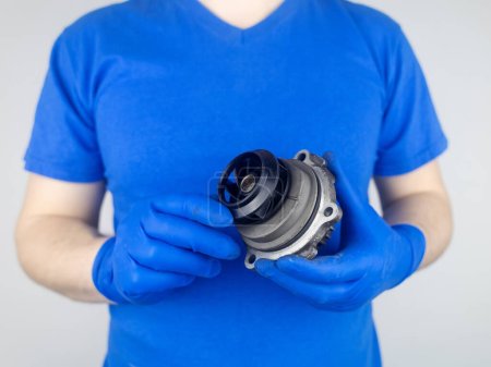 Photo for Timing belt cracked. Replacing a failed engine transmission belt. Cracks in rubber and risk of broken cords. Replacement of equipment according to the regulations. Mechanic in blue gloves - Royalty Free Image