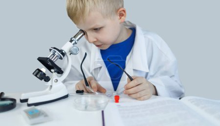 Químico infantil. El profesor muestra un experimento visual. Un mentor científico enseña un enfoque experimental. Microscopio, placa de Petri, pipetas, libros. Trabajo práctico en química o física. Trabajos de laboratorio