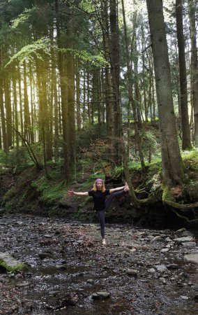 Yoga in nature. Girl in middle of forest conducts a retreat for herself. Individual practice in unity with nature. Solopractic in meditation and Vedic exercises. Forests of the Carpathians, Ukraine