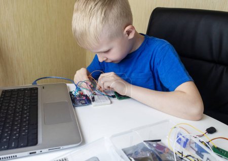 Programming for children. The boy is studying online at a robotics school for programming courses. Child learning control board coding