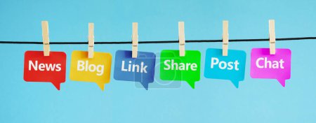Web- und Internetkonzept mit sozialen Medien und sozialen Netzwerken Wörter Nachrichten, Blog, Link, teilen, posten und chatten auf bunten Papier Sprechblasen auf blauem Hintergrund aufgehängt.