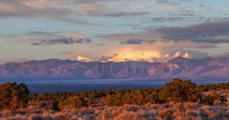 Foto de Taos Valley, New Mexico at sunset with a thunderstorm developing on the east side of the Sangre de Cristo Mountains. - Imagen libre de derechos