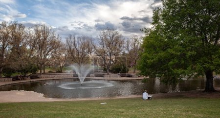 Foto de Estanque de Patos de la Universidad de Nuevo México en Albuquerque. Fue construido a finales de la década de 1970 y se ha convertido a lo largo de las décadas en un sitio popular. Se modificó el color de pelo y la ropa de la niña en primer plano. - Imagen libre de derechos