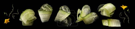 Foto de Conjunto de rodajas de pepino con flor y guirnalda en espiral sobre fondo negro - Imagen libre de derechos