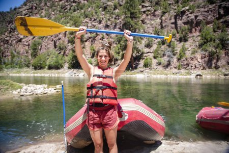 Téléchargez les photos : Jeune femme excitée descendant la rivière Green River en rafting pendant ses vacances d'été dans l'Utah. Amusement extérieur actif en été aux États-Unis - en image libre de droit