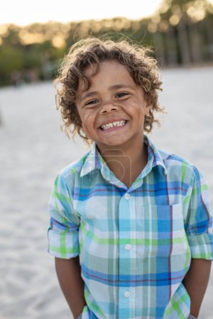 Foto de Charming Beautiful Black young boy with a playful smile and curly hair. Outdoor candid portrait of a natural beauty - Imagen libre de derechos
