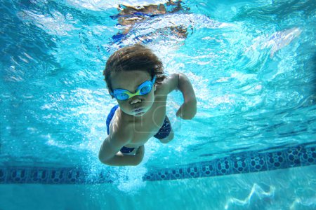 Téléchargez les photos : Plaisir de jeune garçon sous-marin dans la piscine avec lunettes. Vacances d'été Fun
. - en image libre de droit