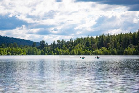 Photo for Two women Kayaking on a pristine mountain lake in the state of Washington Pacific Northwest. Scenic landscape horizontal photo depicting the great state of Washington - Royalty Free Image