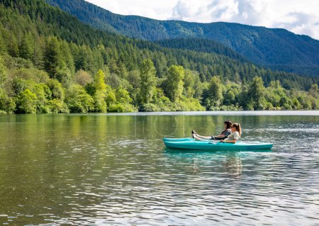 Téléchargez les photos : Deux femmes Kayak sur un lac de montagne vierge dans l'État de Washington Pacifique Nord-Ouest. Paysage panoramique photo horizontale de deux amis profitant du grand air ensemble - en image libre de droit