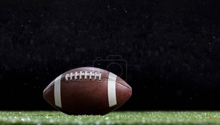 Téléchargez les photos : American Football resting on the field of a Football stadium during a game. Copy space and good generic sports image - en image libre de droit