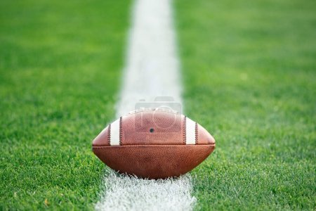 Photo for Close up view of an American Football sitting on a grass football field on the yard line. Generic Sports image - Royalty Free Image