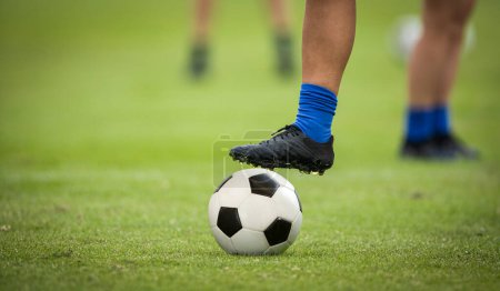Photo for Close up of a foot resting on top of a soccer ball at a soccer field. Good Soccer concept photo - Royalty Free Image