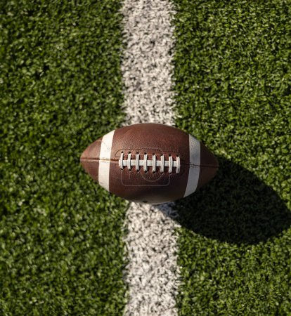 Photo for American football resting on a kicking tee stand ready to be kicked to start off a football game. The football game is ready to begin. Time for Kickoff - Royalty Free Image