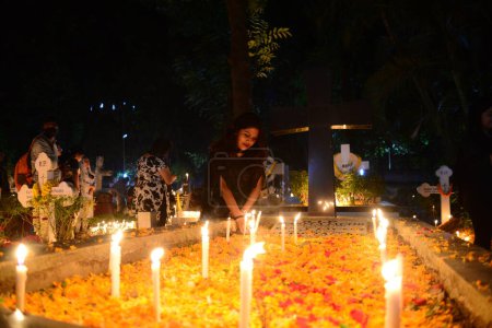 Téléchargez les photos : Les dévots chrétiens allument des bougies sur les tombes de leurs proches lors des célébrations de la Toussaint dans un cimetière au cimetière Wari de l'église Sainte-Croix à Dacca, Bangladesh, le 2 novembre 2022. - en image libre de droit
