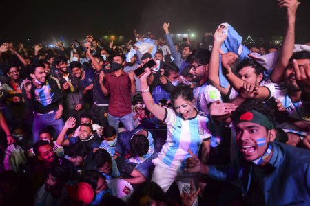 Photo for Bangladeshi Argentinian supporters react as they watch the final football match of the Qatar 2022 World Cup between Argentina and France at the Dhaka University Campus in Dhaka, Bangladesh on December 18, 2022. - Royalty Free Image