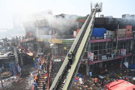 Foto de Bomberos, fuerzas de seguridad y rescatistas tratando de extinguir un incendio que estalló en el mercado de ropa New Supper Market en Dhaka, Bangladesh, el 15 de abril de 2023. Miles de tiendas de ropa se queman en el fuego, asestando un golpe significativo a Busine - Imagen libre de derechos