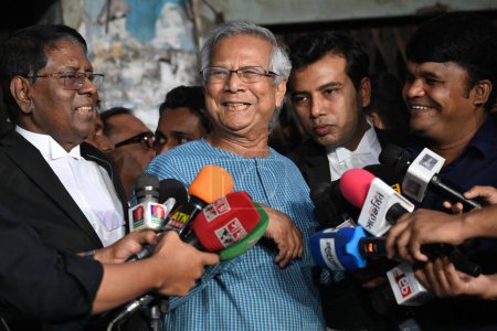 Téléchargez les photos : Le Prof Muhammad Yunus (C), lauréat du prix Nobel, s'entretient avec un journaliste après une audience au tribunal du travail à Dacca, Bangladesh, le 20 novembre 2023 - en image libre de droit