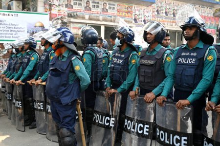 Foto de Personal de policía hace guardia durante familiares de líderes y activistas del principal partido de oposición encarcelado (BNP) sostuvieron una cadena humana exigiendo la liberación inmediata de todos los líderes y activistas en Dhaka, Bangladesh, el 28 de noviembre de 2023 - Imagen libre de derechos