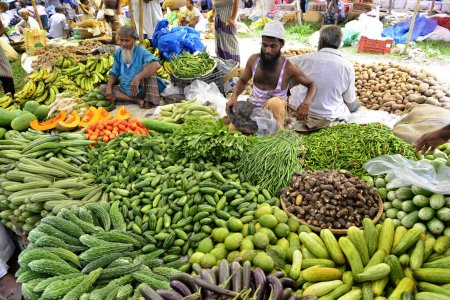 Photo for A shopkeeper waiting for customers to sale vegetables at Kaikkarateke weekly market, Narayanganj district in Bangladesh, On June 21, 2015 - Royalty Free Image