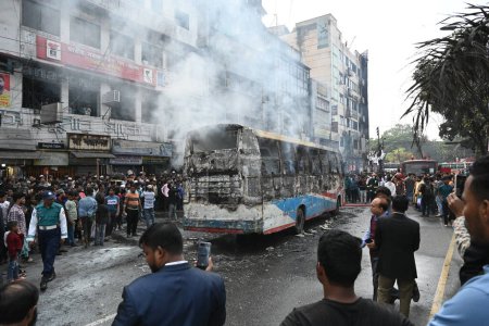 Foto de Los bomberos extinguen un autobús supuestamente incendiado durante la huelga nacional en Dhaka, Bangladesh, el 19 de diciembre de 2023. El Partido Nacionalista de Bangladesh (BNP) y los partidos aliados llamaron a otra huelga nacional para presionar - Imagen libre de derechos