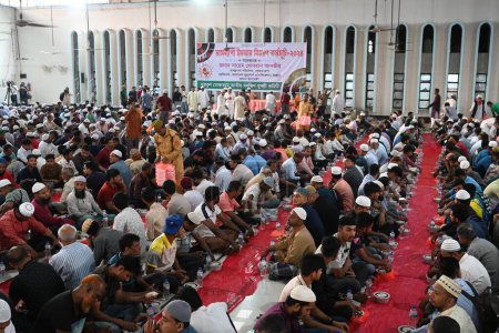 Téléchargez les photos : Les dévots musulmans s'assoient ensemble avant de rompre leur jeûne pendant le mois sacré du Ramadan à la mosquée nationale Baitul Mukarram à Dacca, Bangladesh, le 13 mars 202 - en image libre de droit