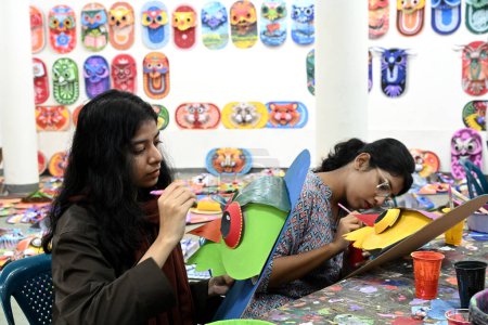 Téléchargez les photos : Étudiant de la Faculté des beaux-arts de l'Université de Dacca masques de peinture pour une préparation colorée pour célébrer le Nouvel An bengali 1431 à Dacca, Bangladesh, le 30 mars 2024. Pahela Baishakh (le premier jour du mois de Bangla) peut être suivie en arrière - en image libre de droit