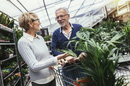 Photo for Senior couple are choosing potted plant at garden center. - Royalty Free Image