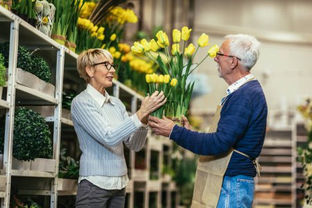 Foto de Mujer mayor comprando flores en la florería local. - Imagen libre de derechos