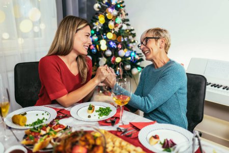 Téléchargez les photos : Mère et fille passer un bon moment au dîner de Noël - en image libre de droit