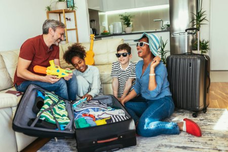 Téléchargez les photos : Happy family having great time and packing for summer holidays - en image libre de droit