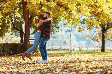 Téléchargez les photos : Jeune couple heureux se regardant tout en se tenant la main et en marchant dans le parc. - en image libre de droit