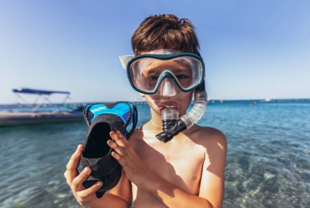 Téléchargez les photos : Portrait d'un petit garçon souriant avec masque de plongée et tuba en bord de mer - en image libre de droit