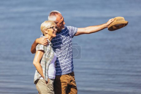 Téléchargez les photos : Mature couple relaxing together at the beach - en image libre de droit