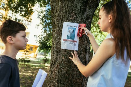 Téléchargez les photos : Les enfants sont à la recherche d'un chien disparu, portant des affiches. - en image libre de droit