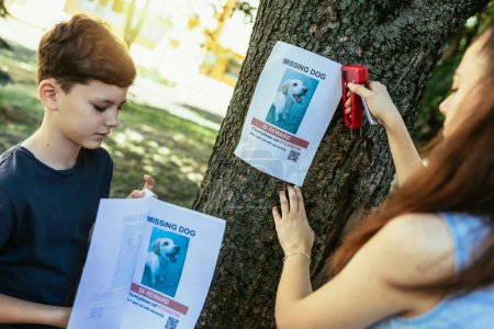 Foto de Los niños están buscando un perro desaparecido, colocando carteles. - Imagen libre de derechos