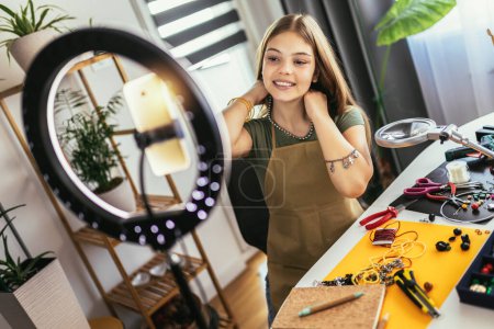 Photo for Teenage girl accessories designer making handmade jewelry in studio workshop and recording video. Fashion, creativity and handmade concept. - Royalty Free Image