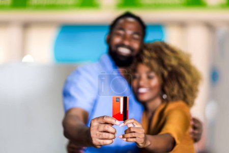 Photo for Portrait of smiling black couple showing credit credit card walking in the city shopping mall or supermarket. - Royalty Free Image