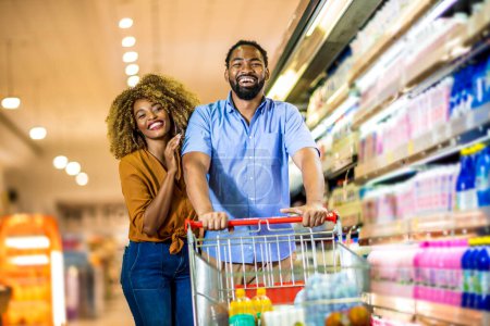 Photo for African American couple with trolley purchasing groceries at mall - Royalty Free Image