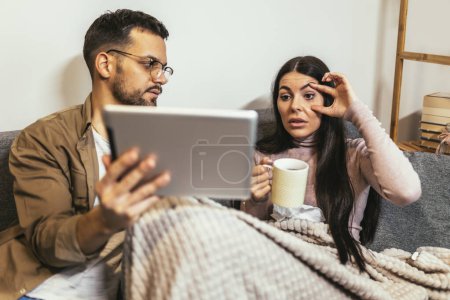 Photo for Young ill couple having medical teleconsultation using digital tablet at home. - Royalty Free Image